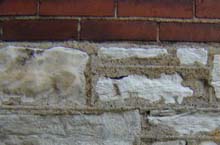 Limestone foundation with brick above