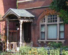 Brick house with painted wooden porch and window